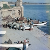 Fisherman launching boat by ruin
